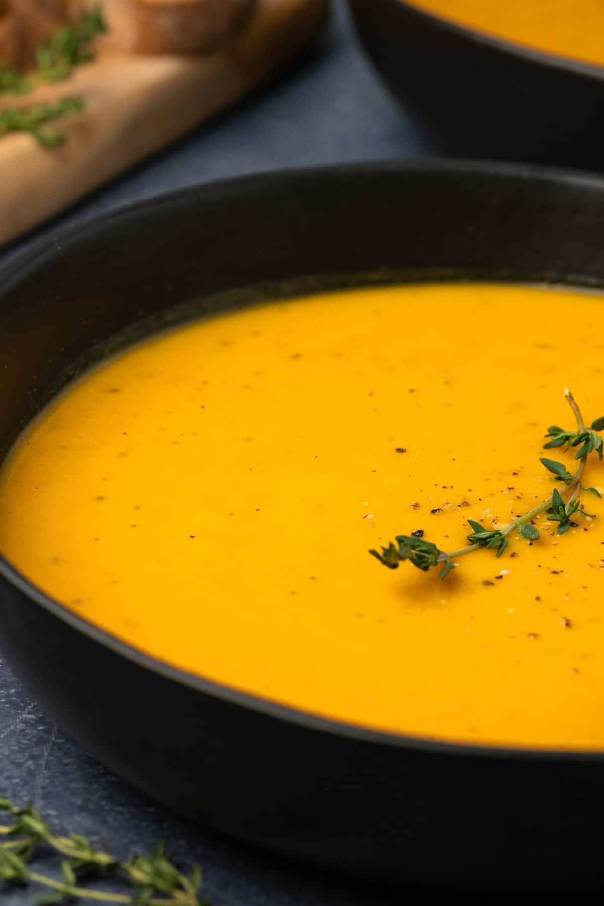 Roasted butternut squash soup topped with a sprig of fresh thyme. 