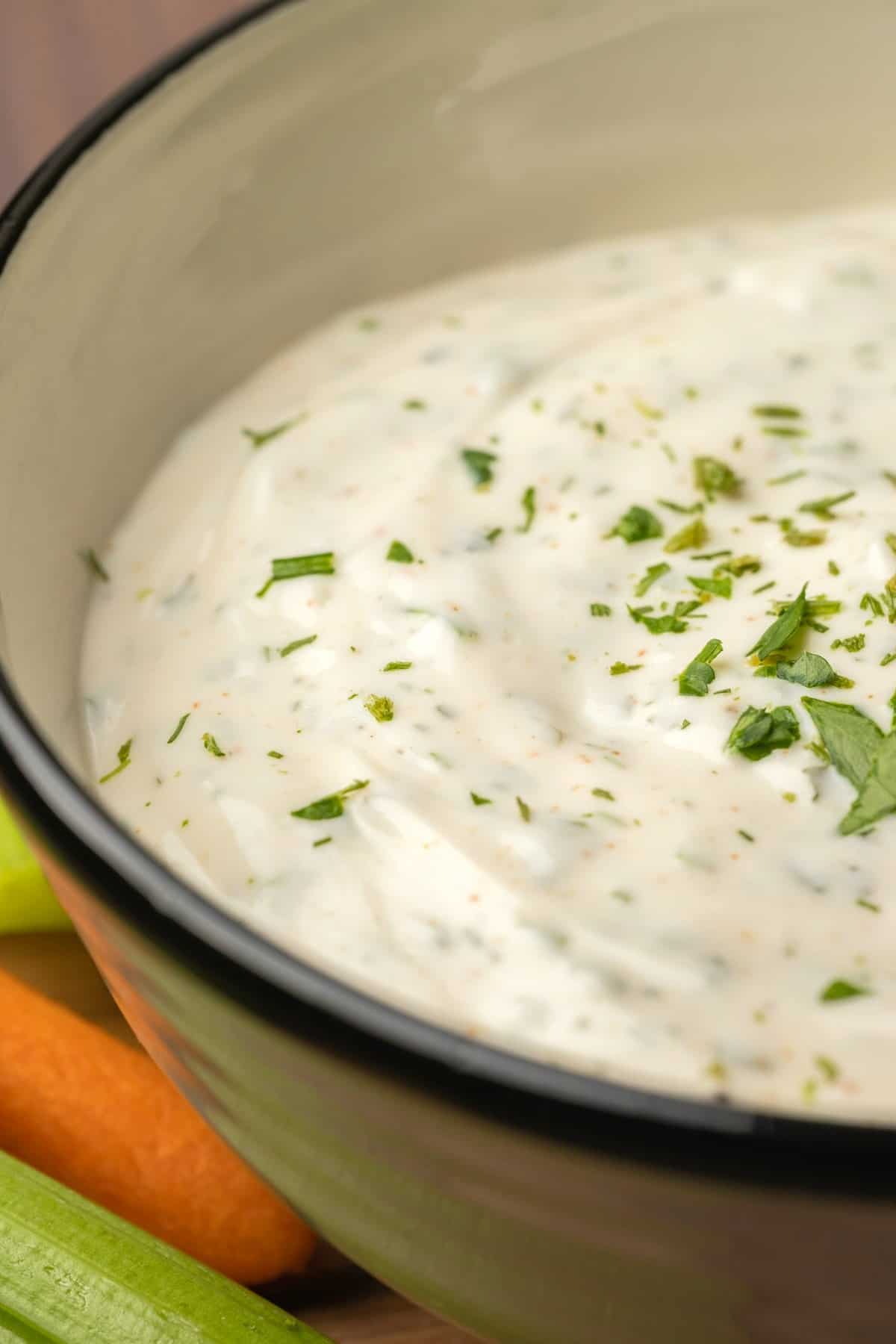 Ranch dressing in a ceramic bowl topped with fresh parsley.