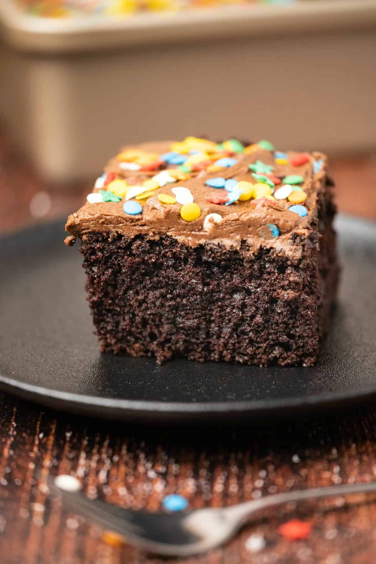 Slice of cake on a black plate. 