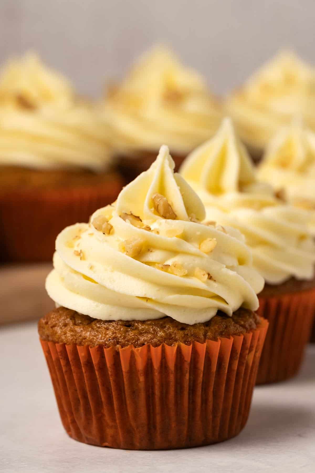 Cupcakes with piped frosting and chopped nuts.