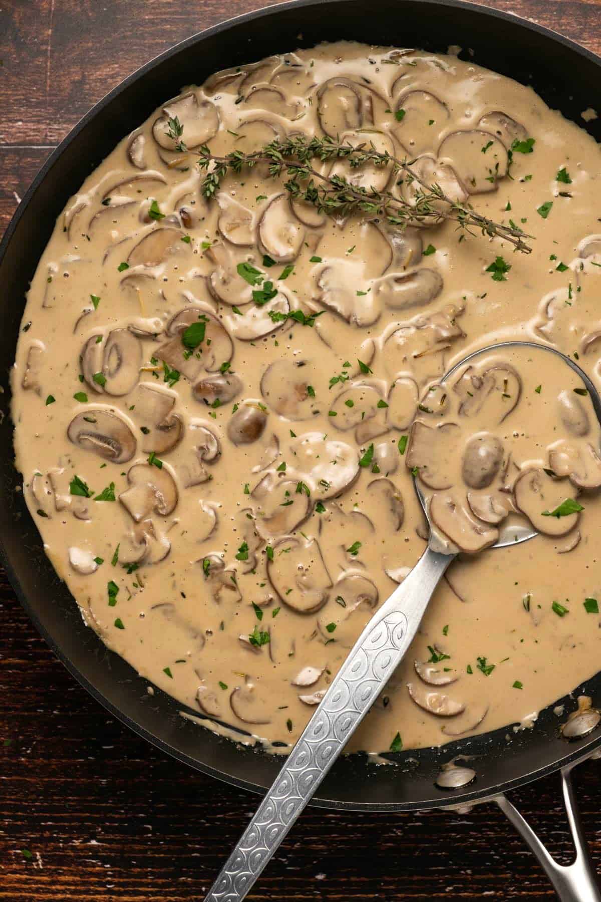 Mushroom sauce in a skillet with a serving spoon. 