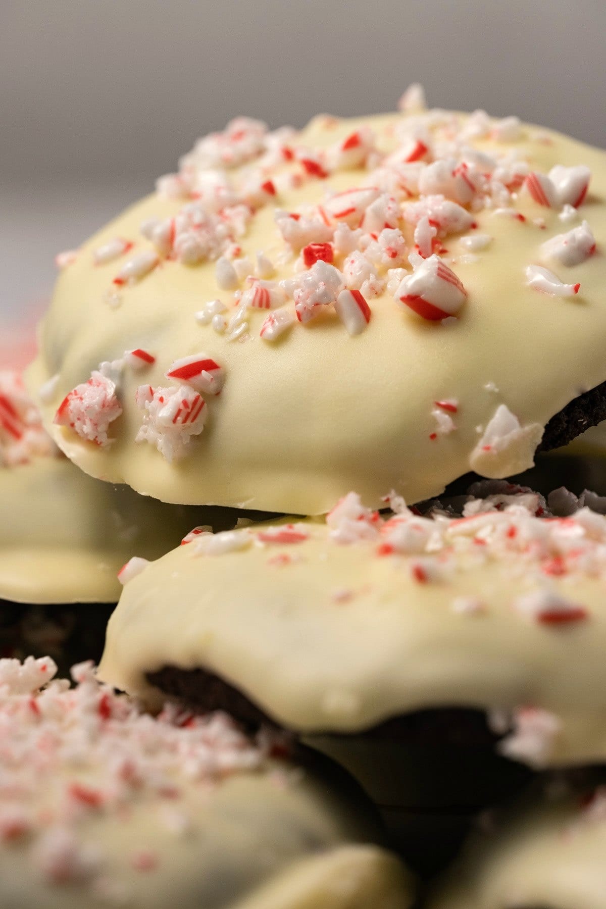 Cookies topped with white chocolate and candy canes in a stack. 