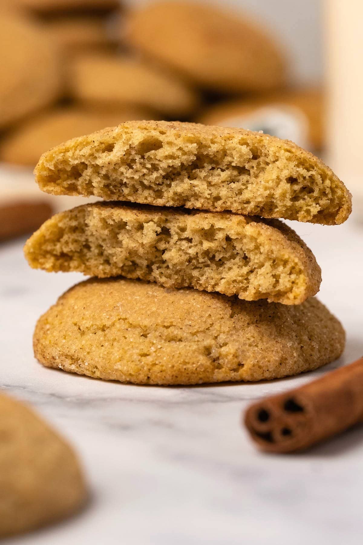 Snickerdoodles in a stack, with the top cookie broken in half.