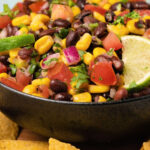 Black bean salsa with fresh lime in a black bowl