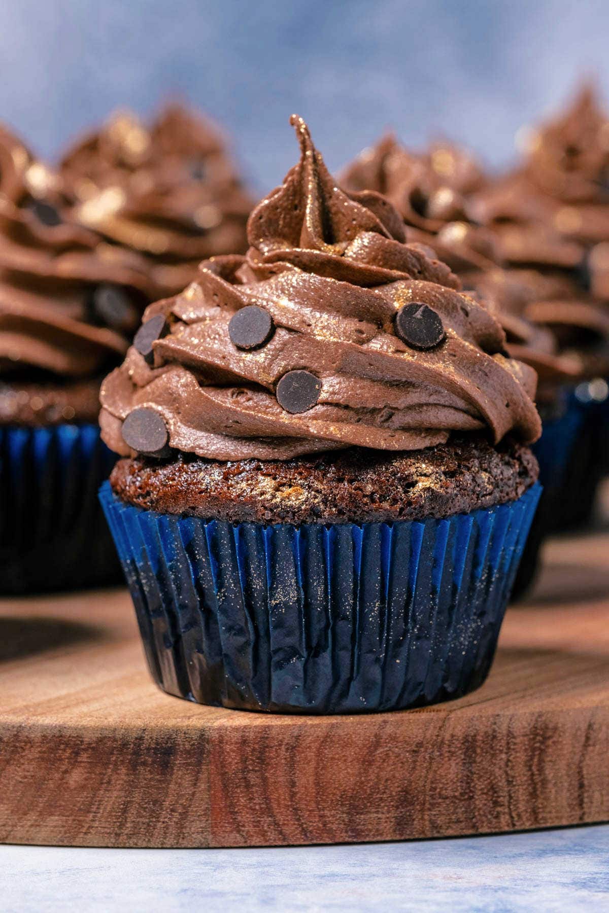 Eggless chocolate cupcakes on a wooden board.