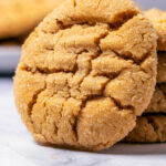 Peanut butter cookie leaning against a stack of cookies.