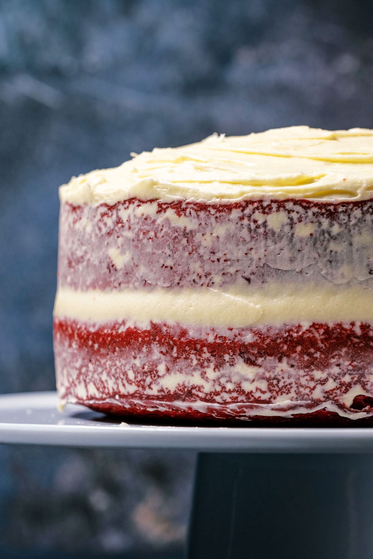 Eggless red velvet cake on a white cake stand.