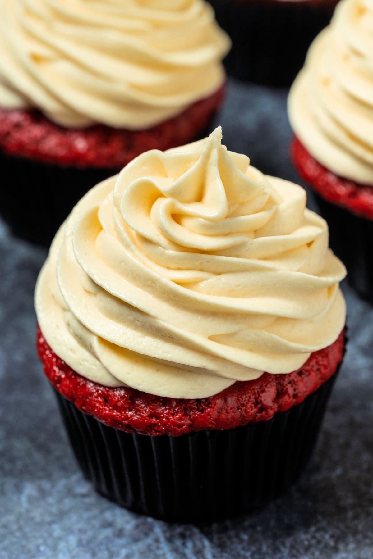 Close up of a cupcake topped with white chocolate cream cheese frosting.