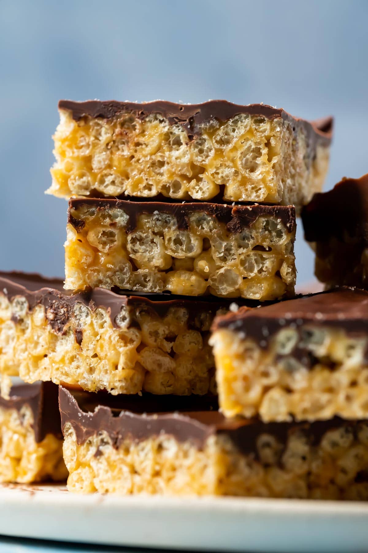 Peanut butter rice krispie treats stacked up on a white plate.