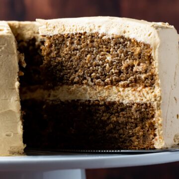 Sliced eggless coffee cake on a white cake stand.