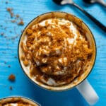 Biscoff mug cake topped with whipped cream, drizzled biscoff cookie butter and crushed biscoff cookies.