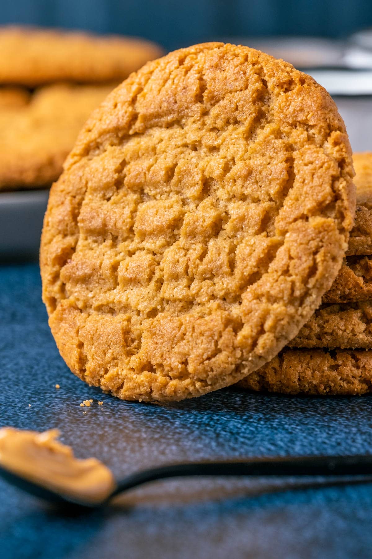 Peanut butter almond flour cookie leaning against a stack of cookies.