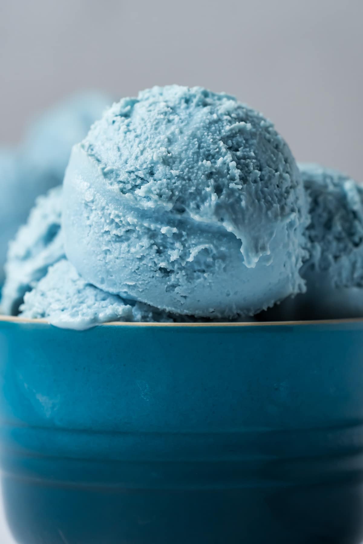 Scoops of cotton candy ice cream in a blue bowl.