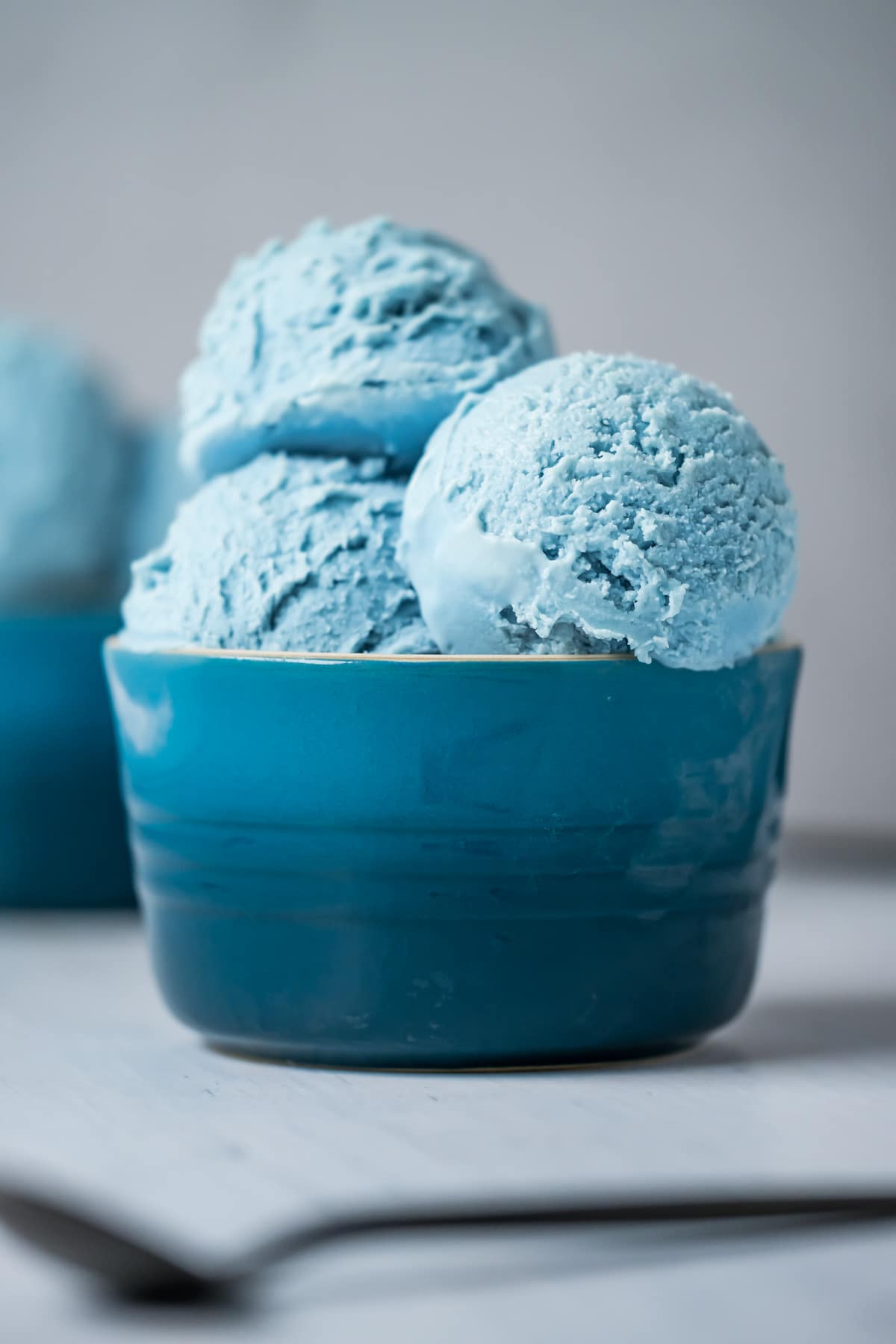 Scoops of cotton candy ice cream in a blue bowl.