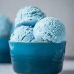 Cotton candy ice cream scoops in a blue bowl.