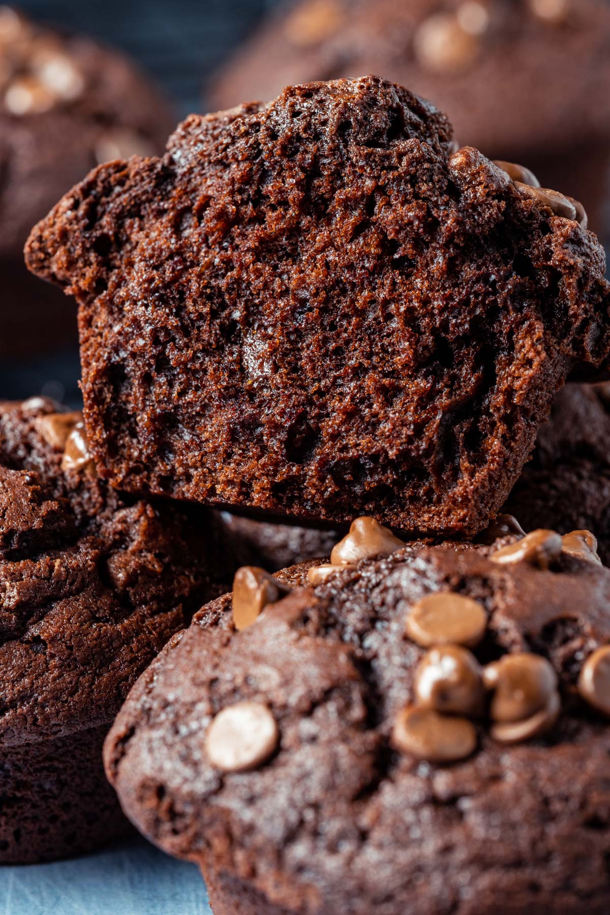 Stack of chocolate muffin with the top muffin broken in half.