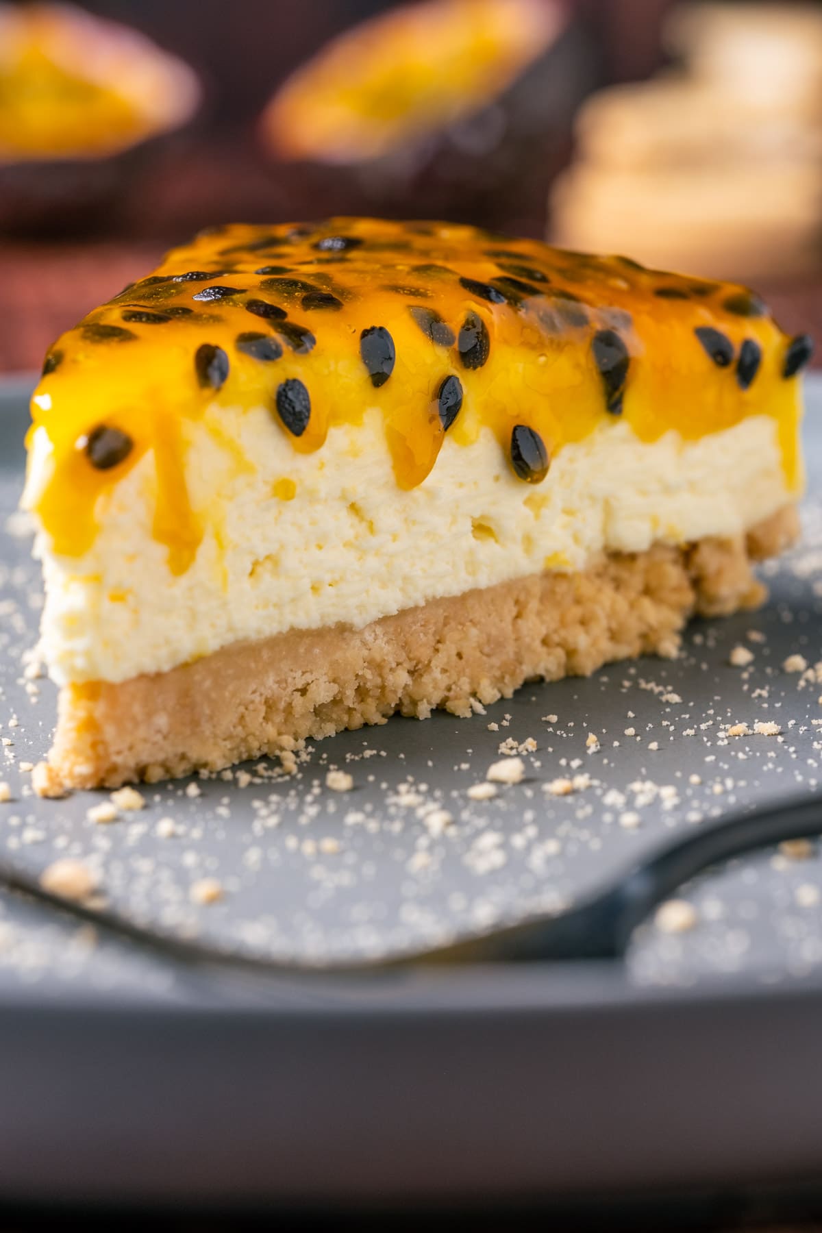 Slice of passion fruit cheesecake on a plate with a cake fork.