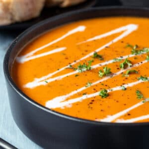 Tomato soup in a black bowl.