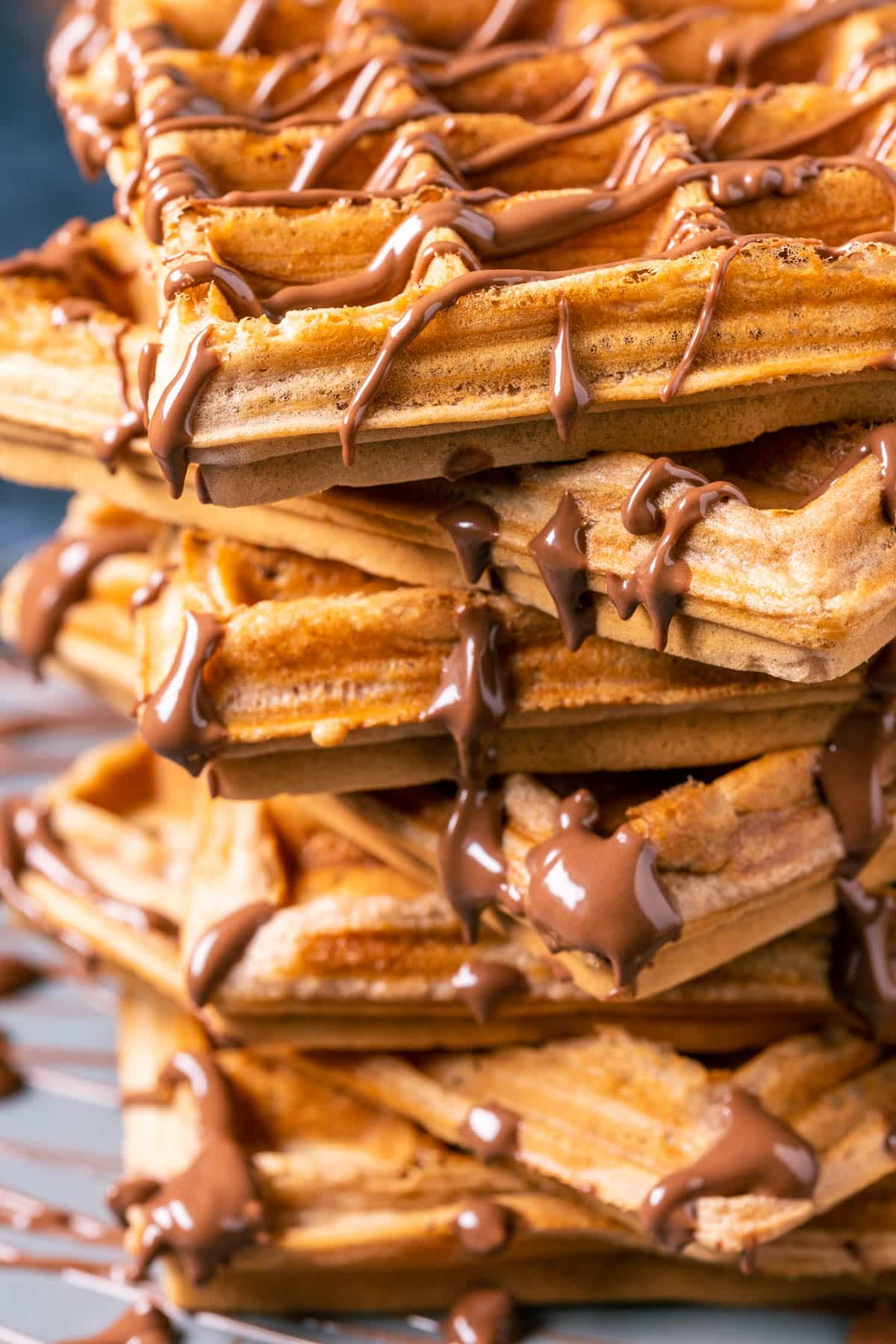 Stack of nutella waffles drizzled with melted nutella.
