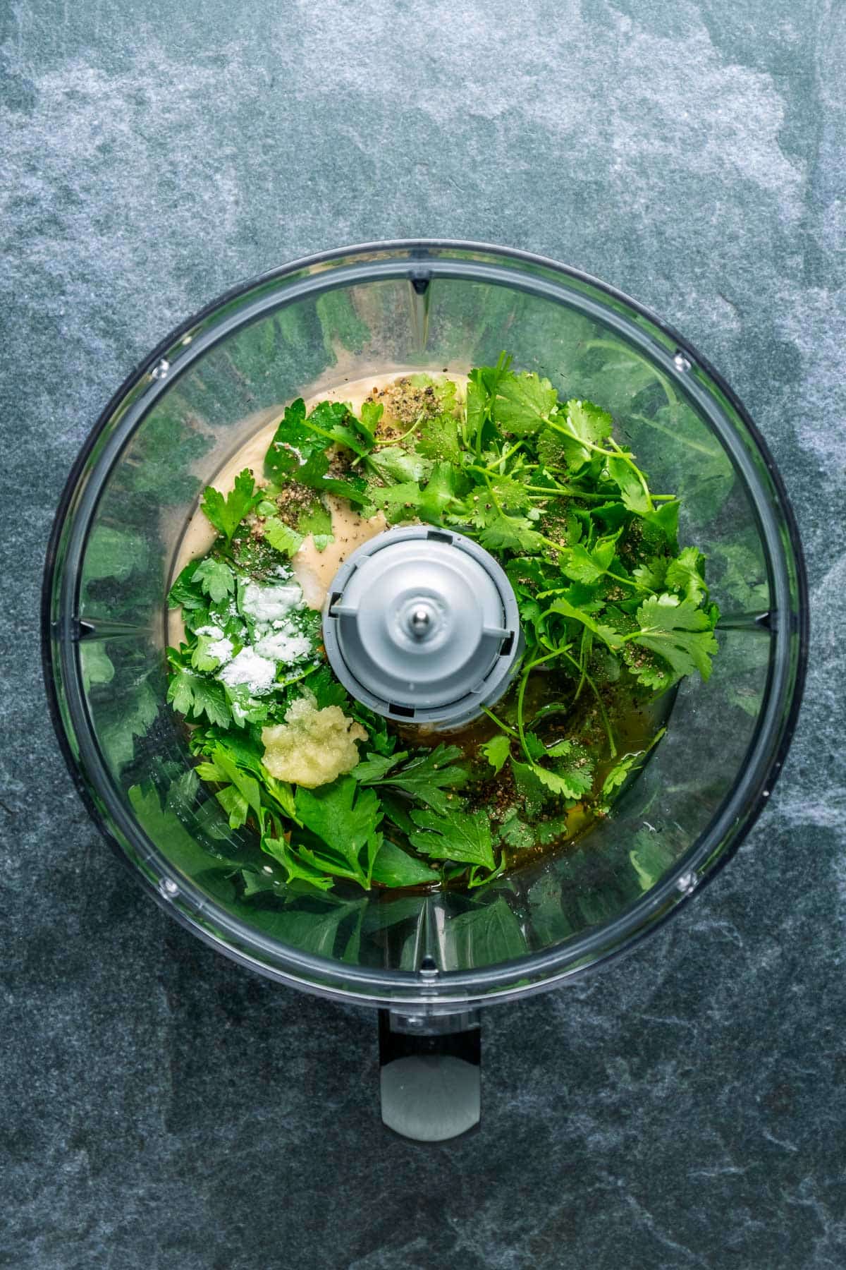 Ingredients for lemon herb tahini in a food processor.