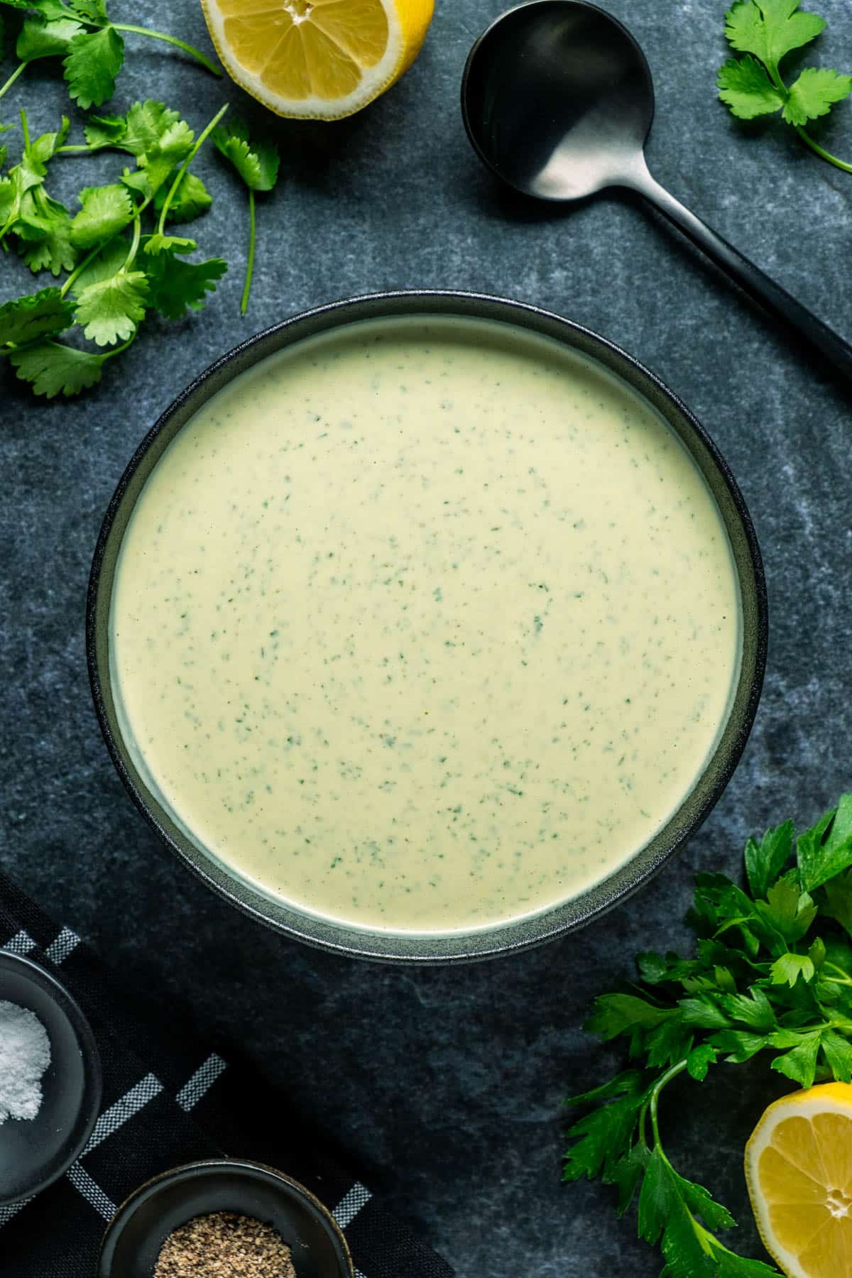 Tahini sauce in a black bowl.