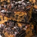 Stacked Oreo blondies on a white plate.